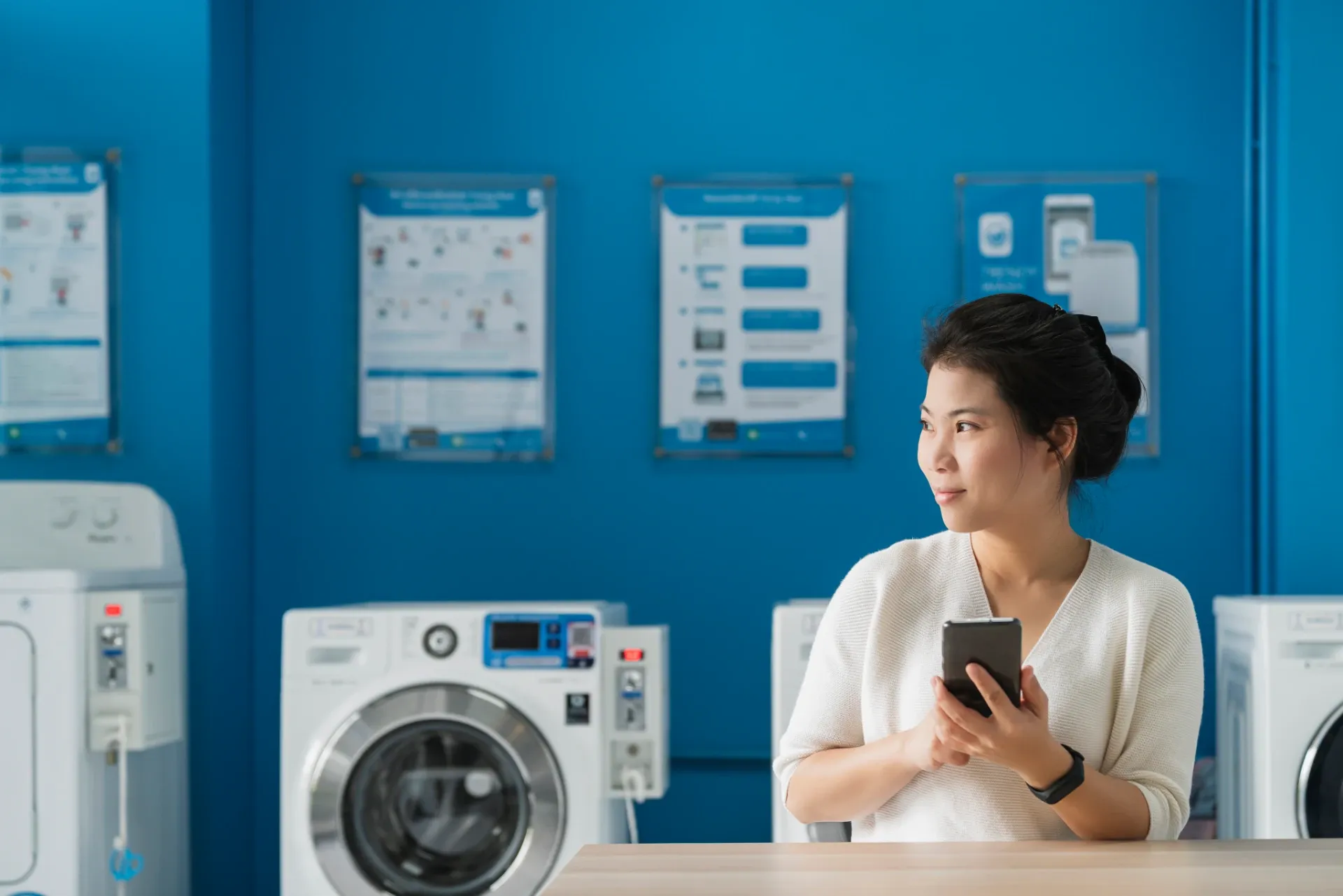Customer using a smartphone at a self-service laundry